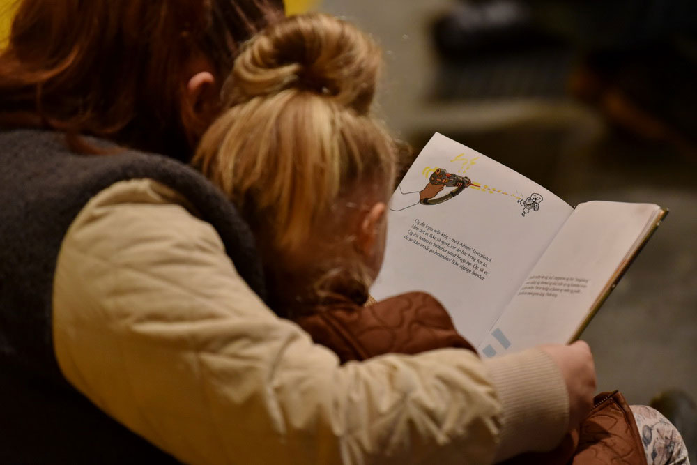 Ett barn och en förälder läser en Alfons Åberg bok